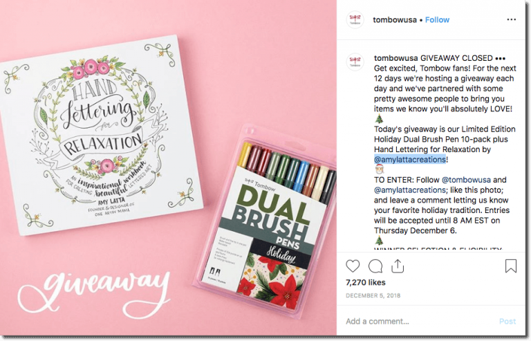 A Christmas Instagram giveaway from Tombow USA. Day 1: the image shows a book and a pack of color pens against a pink background, with the word "giveaway" in white calligraphed text. Users have to follow Tombow and the book's author, like, and comment with their favorite holiday tradition.